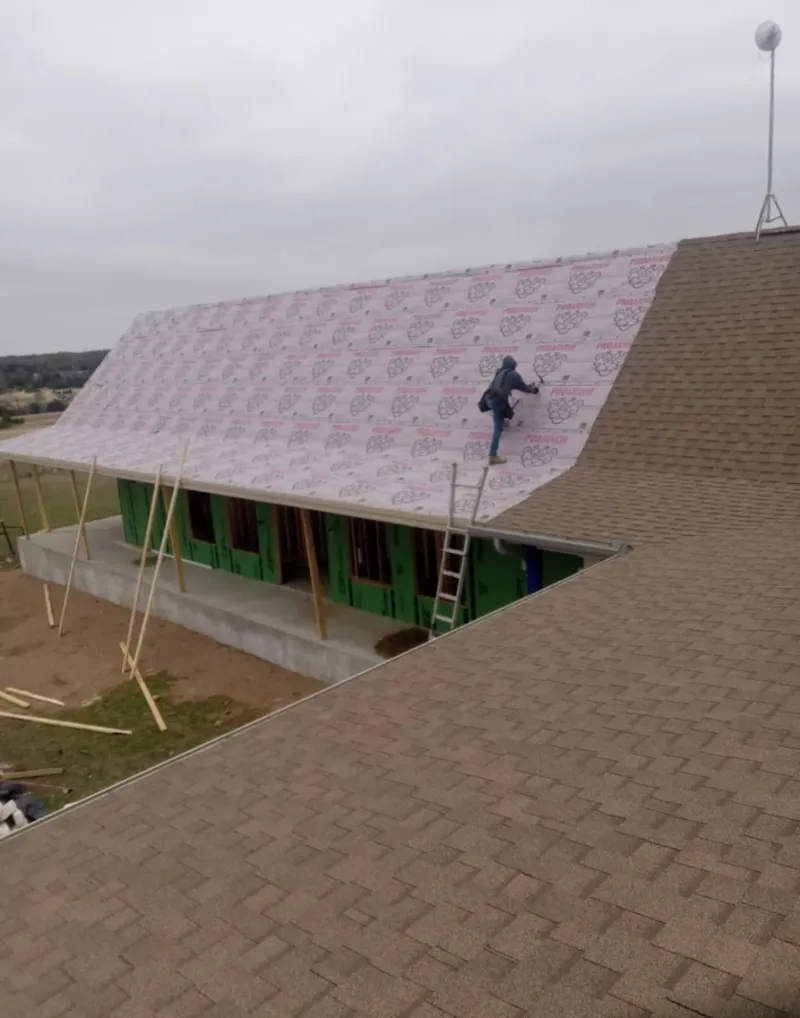 Worker preparing underlayment for a metal roof installation in Gaithersburg